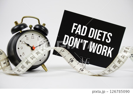 Fad Diets Don't Work text with alarm clock and measuring tape on white background 126785090