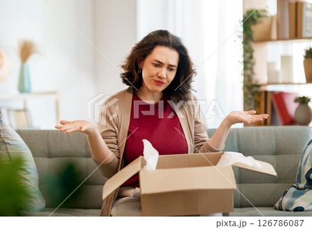 Woman is unpacking cardboard Woman is unpacking cardboard 126786087