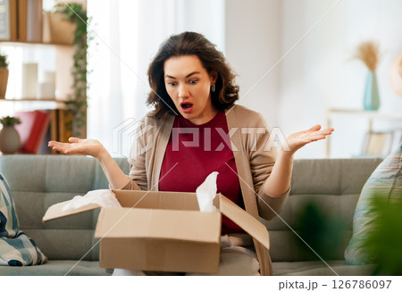 Woman is unpacking cardboard Woman is unpacking cardboard 126786097