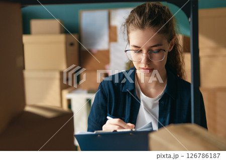 Woman working in a warehouse. 126786187