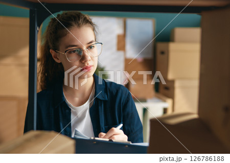 Woman working in a warehouse. 126786188