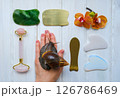 Spa concept gua sha massage body and face care and snails achatina on hand, flat lay. High quality photo Spa concept gua sha massage body and face care and snails achatina on hand, flat lay. High quality photo 126786469