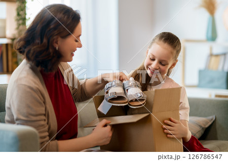 Mother and daughter are unpacking cardboard 126786547
