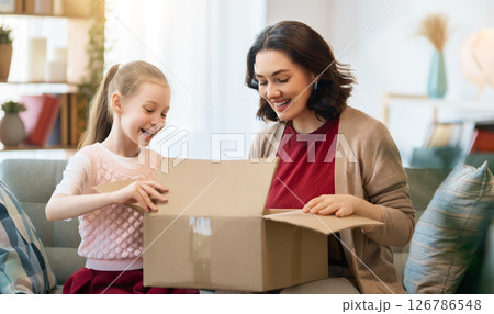 Mother and daughter are unpacking cardboard 126786548