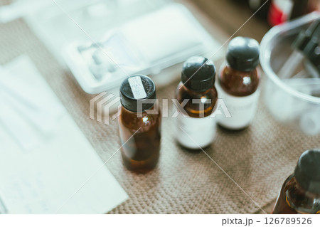 Shot of mature perfumer adding extra essential oil Shot of mature perfumer adding extra essential oil 126789526