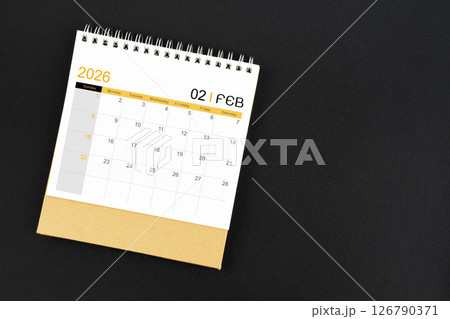 Top view of February 2026 desk calendar on black leather background. 126790371