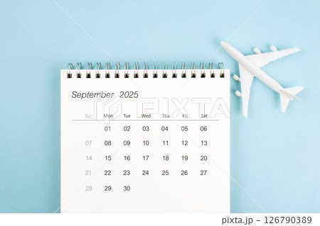 September 2025 calendar and airplane toy on blue background, Travel plan concepts. September 2025 calendar and airplane toy on blue background, Travel plan concepts. 126790389