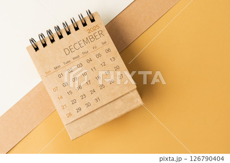 Blank desk calendar for December 2025 on brown tone background. Blank desk calendar for December 2025 on brown tone background. 126790404