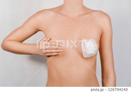 Close-Up of Woman's Breast Covered with Band-Aids After Nipple and Areola Correction Surgery Close-Up of Woman's Breast Covered with Band-Aids After Nipple and Areola Correction Surgery 126794240