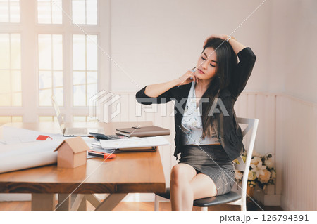 Office syndrome concept. Business Woman twisting the body to relieve fatigue , suffering from pain after sedentary working in incorrect posture for a long time . 126794391