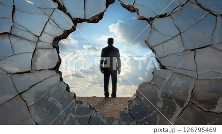 Cracked mirror reflection of a standing figure against a cloudy sky 126795469