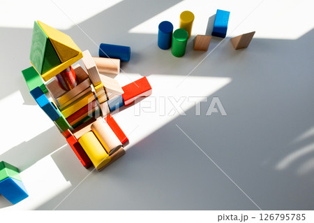Colorful wooden building blocks in sunlight on white background Colorful wooden building blocks in sunlight on white background 126795785