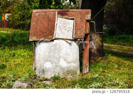 Old abandoned rusty water well decaying in the countryside 126795918