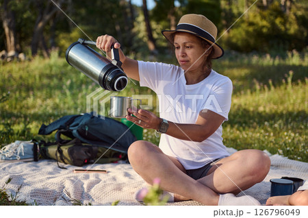 Woman Enjoying a Relaxing Outdoor Picnic in a Summer Forest Setting Woman Enjoying a Relaxing Outdoor Picnic in a Summer Forest Setting 126796049