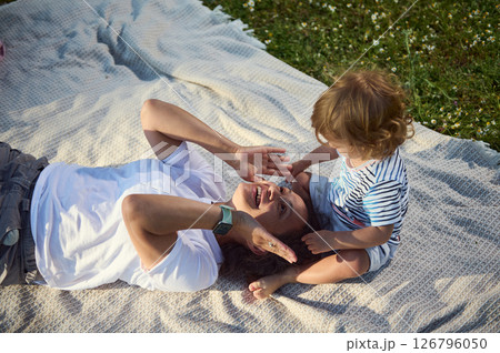 Mother and Child Sharing Moments on a Picnic Blanket Outdoors 126796050