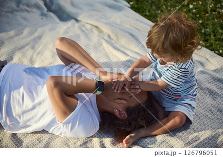 Mother and Child Enjoying Quality Time Together Outdoors on a Blanket 126796051