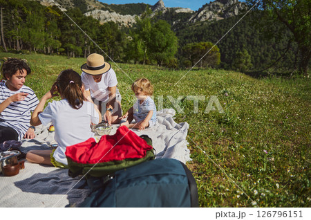Family Enjoying a Picnic in the Mountains Tasting Tacos Outdoors 126796151