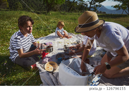 Family Picnic in Beautiful Mountain Landscape with Emotional Bonding and Shared Meal 126796155
