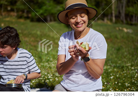 Mother Enjoying a Picnic Outdoors in the Mountains With Her Child Mother Enjoying a Picnic Outdoors in the Mountains With Her Child 126796304