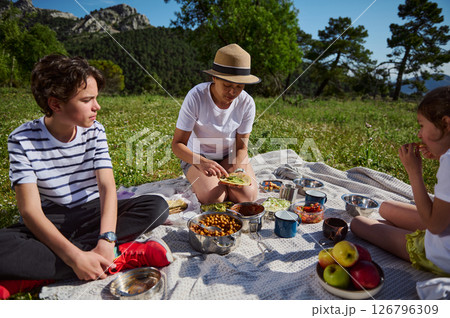 Family Enjoying a Relaxing Picnic in the Mountains During a Sunny Day Family Enjoying a Relaxing Picnic in the Mountains During a Sunny Day 126796309