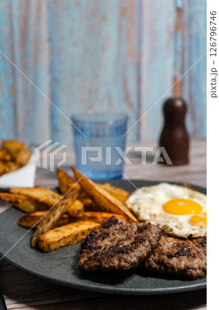 Close-up of gourmet homemade burger with egg and potatoes. 126796746