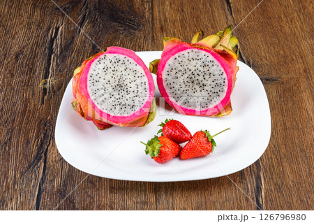 Dragon fruit or pitahaya and strawberries on a white plate. 126796980