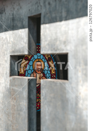 Stained Glass Image of Jesus Seen Through a Metal Cross Opening 126797020
