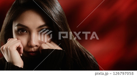 Young woman hiding her face with her hands on a red background Young woman hiding her face with her hands on a red background 126797058