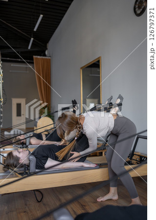 A detailed closeup of a foot work and core exercise on a Balanced Body Reformer machine illuminated by sunlight A detailed closeup of a foot work and core exercise on a Balanced Body Reformer machine illuminated by sunlight 126797371