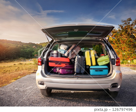 Preparing for a road trip with packed luggage in the trunk of an SUV at a scenic location during late afternoon Generative AI 126797496