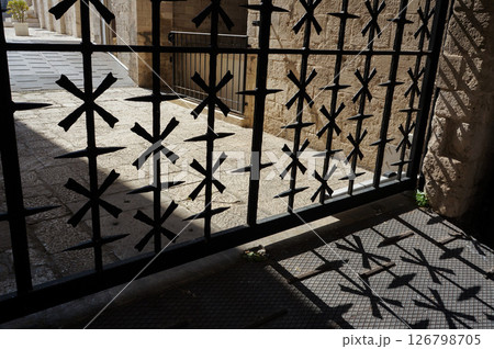 おしゃれな模様をした門が日に当たって影を作る様子 おしゃれな模様をした門が日に当たって影を作る様子 126798705