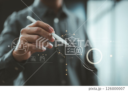 Hand holding stylus interacting with digital checklist and security lock icons on futuristic interface. 126800007