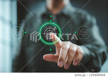 Man pointing at digital target icon with futuristic interface displaying performance metrics and dashboards. 126800008