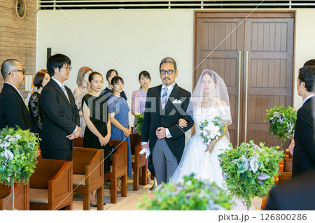 バージンロードを歩く新郎新婦と父親 126800286
