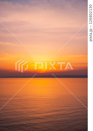 角田岬の夕暮れ：佐渡島に沈む夕日 126802130