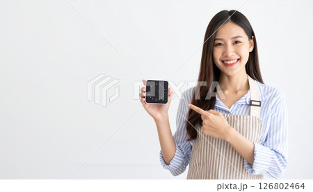 キッチンタイマーを持つエプロンを付けた女性 126802464