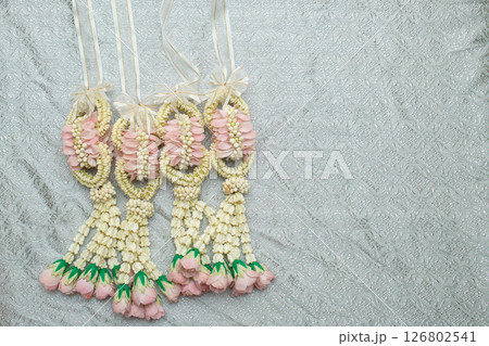 Beautiful Thai-style jasmine garland on a silver cloth background with an ancient Thai pattern. 126802541