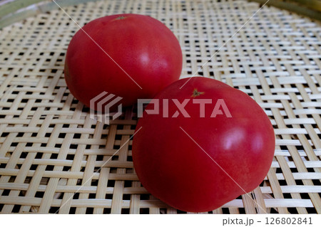 竹を編んだ手作りのざるに乗った無農薬の新鮮な桃太郎トマト 126802841