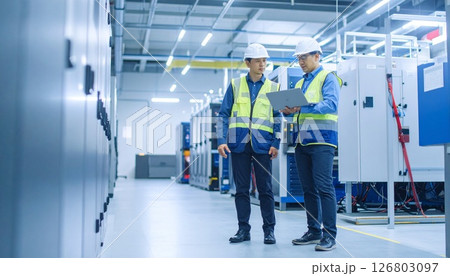 サーバールームでコンピューターをチェックする情報システム担当者 サーバールームでコンピューターをチェックする情報システム担当者 126803097