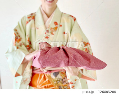 着物を着て紫色の風呂敷包みを持つ女性 126803200