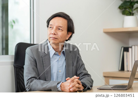 Business Professional in Meeting. A focused businessman discussing financial reports in a modern office. 126803451
