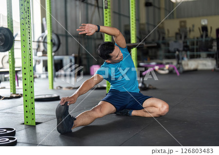 Fitness and Flexibility. Man stretching his side in a gym for improved mobility. 126803483