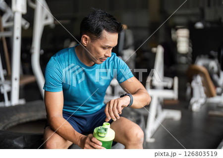 Fitness Enthusiast Checking Smartwatch During Workout Break Fitness Enthusiast Checking Smartwatch During Workout Break 126803519