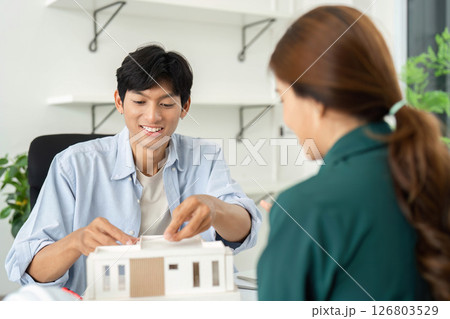 Sustainability and ESG. Young professionals engaging over architectural model. 126803529