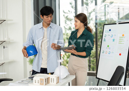 ESG and Sustainability. Young professionals engaged in planning renewable energy strategies. 126803554