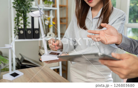 ESG Business Collaboration. Professionals discussing sustainable energy solutions in a modern office. 126803680