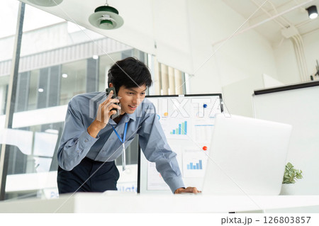 Business Professional on Phone Call. Engaged businessman discussing strategies during a meeting. Business Professional on Phone Call. Engaged businessman discussing strategies during a meeting. 126803857