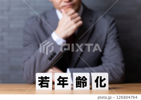 若年齢化のブロックとスーツを着て悩むミドル男性ビジネスマン 126804764