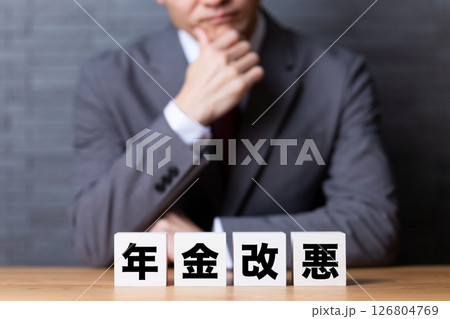 年金改悪のブロックとスーツを着て悩むミドル男性ビジネスマン 126804769