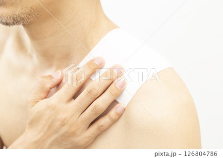 肩に湿布を貼った男性　白バック 126804786